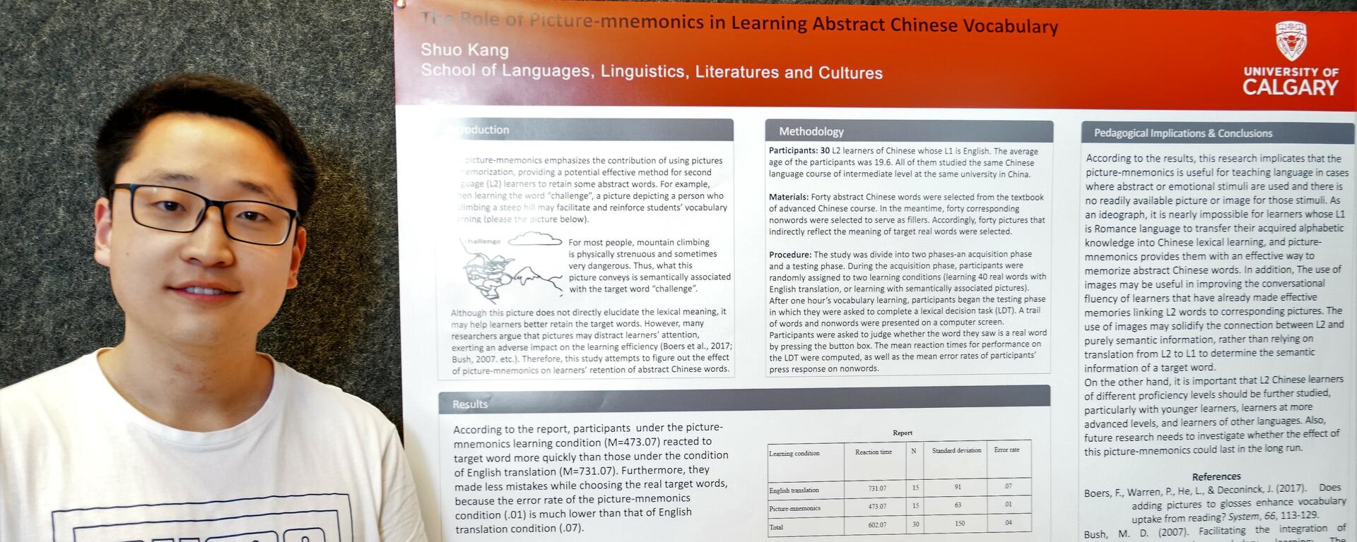 Graduate student stands in front of his research poster