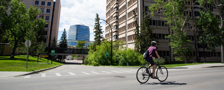 A person rides a bike past the Social Sciences building