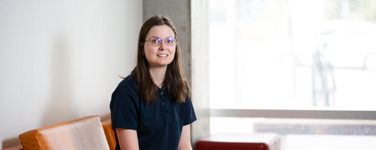 A master's student sits on a chair
