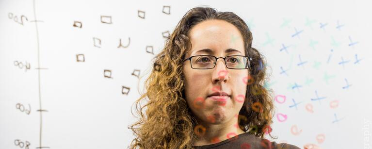A Linguistics graduate student draws symbols on a window