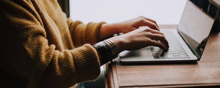 A person typing on a laptop