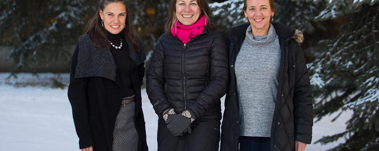 Two researchers stand outside, with snow behind them.