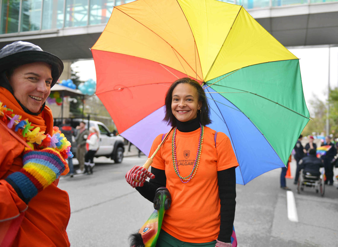 Suzette Mayr at Pride Parade. She is holding a rainbow umbrella.