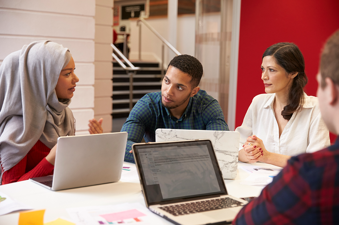 Students of different ethnicities meet for tutorial. One of the students is wearing a hijab.