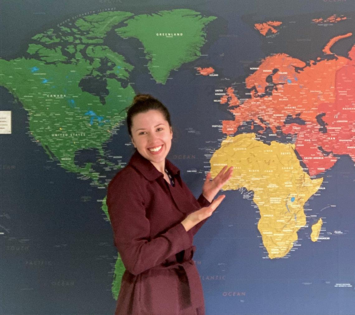 student standing by map