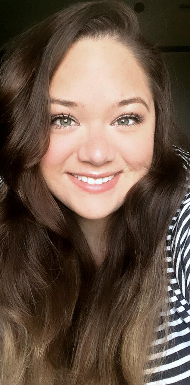 This is a photo of Francine Cunningham smiling at the camera and wearing a striped shirt
