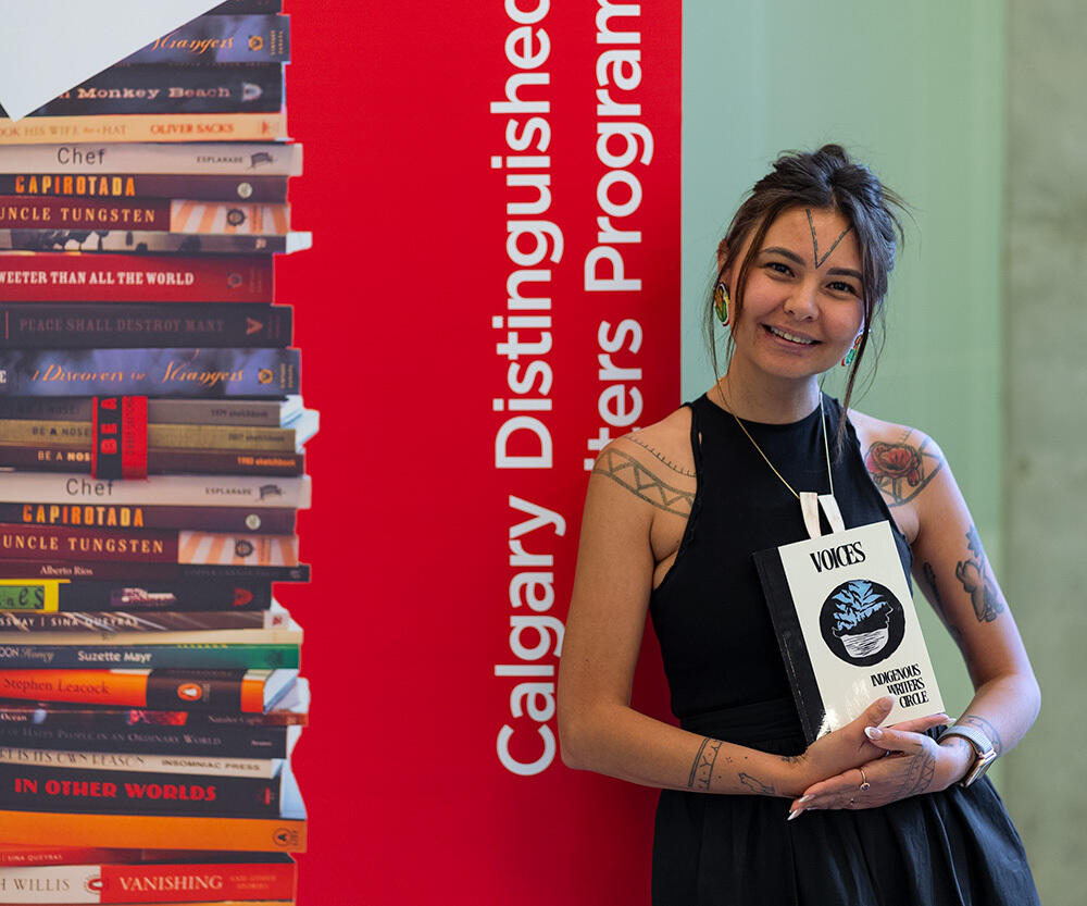 A participant in the 2024 Indigenous Writers Circle holds the anthology Voices.