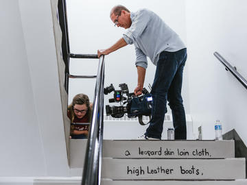 A CTV cameraman records a volunteer repainting the stairs