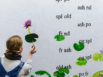 A volunteer artist works on the mural
