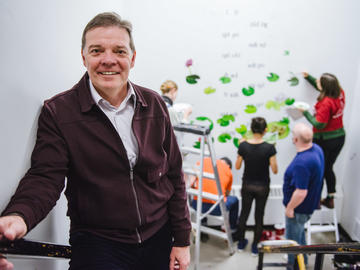 Faculty of Arts Dean Richard Sigurdson in front of the collaborative mural and poem.
