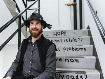 Alumnus Ian Kinney sits in the stairwell.