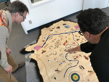 Associate Dean George Colpitts and Adrian Stimson examine the map
