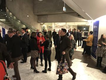 People gather in the gallery space over the map, which is laid on the floor