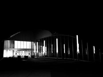 A black and white photo showing the outside of a mall at night