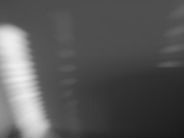 An out of focus, black and white image showing lights and darkness
