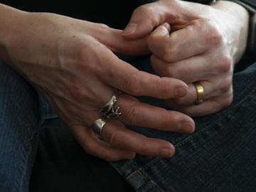 A close-up of a middle-aged woman's hands folded together