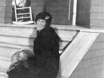 Photo of Winnifred Eaton Reeve sitting beside steps outside of Bow View Ranch (ca. 1920)