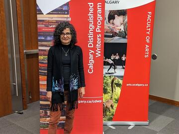 Banoo Zan in front of a CDWP banner.