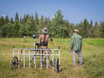 Archaeologists and the landowner survey the land.