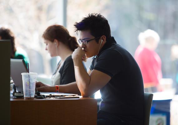 Student working on a comupter in a coffee shop