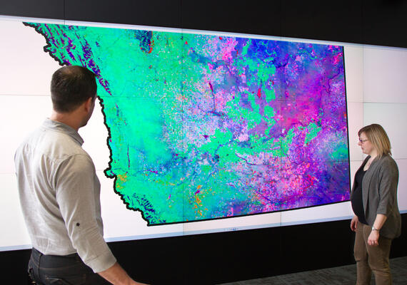 Two people viewing a geography map. 