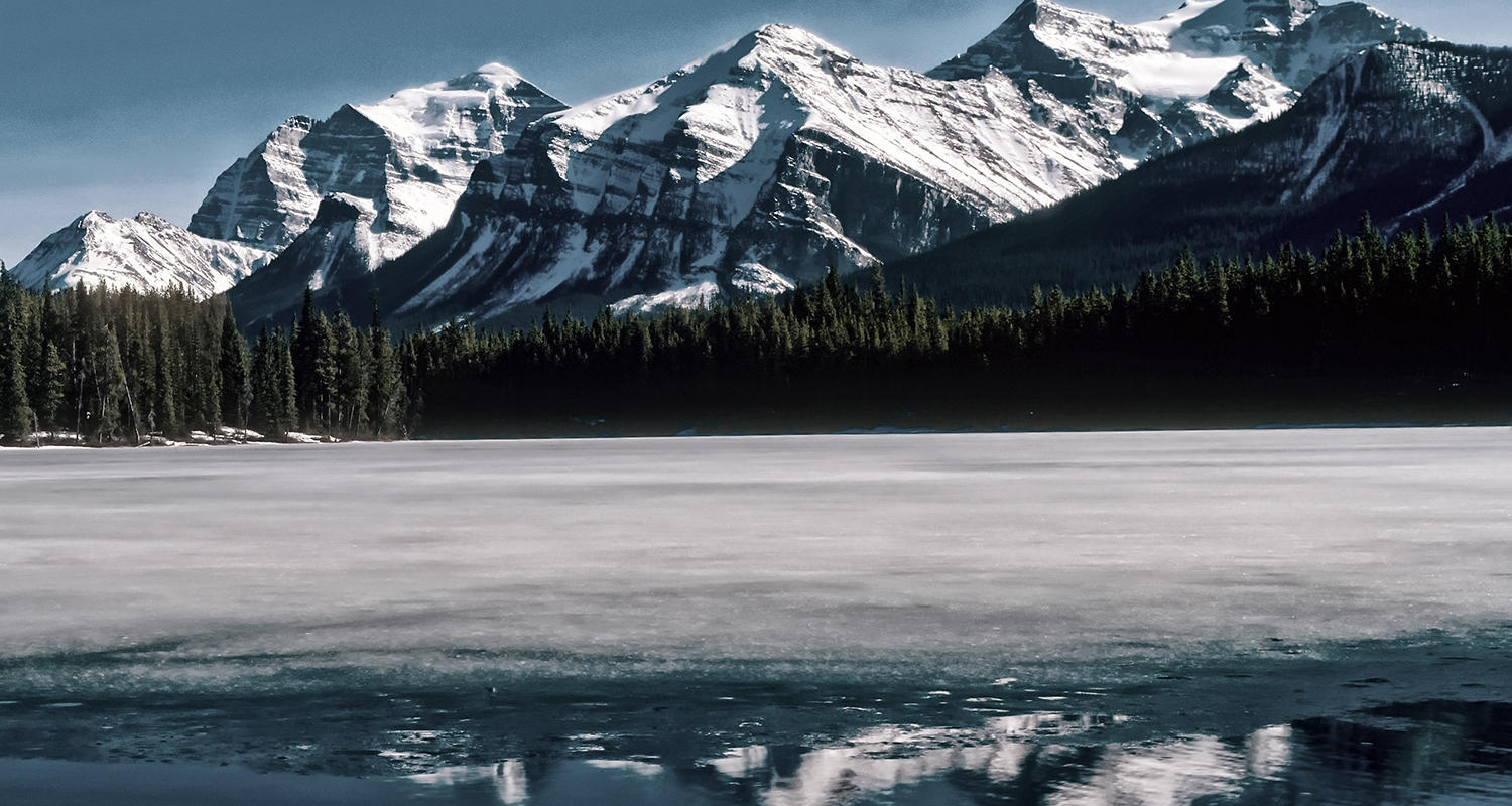 The Rocky Mountains above the forest and a lake