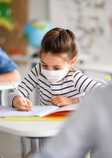 Student working with a mask on