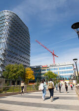 Students walk past the LEED-certified Mackimmie Tower. A crane is visible in background.