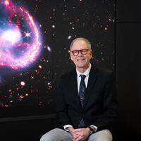 Jim Ellis sitting in front of screen