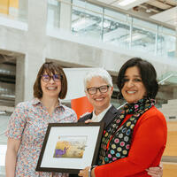 Nisha Abraham receiving an award from the dean
