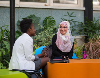 Two students chat in the atrium