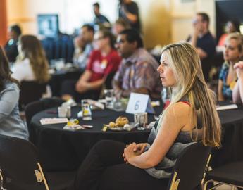 Alumni relations specialist Emily Aalbers and a group of alumni attentively listen to a presentation