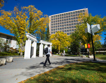 A student walks towards the Social Sciences building in early fall