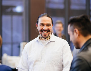 A faculty member smiles at the New Faculty Welcome