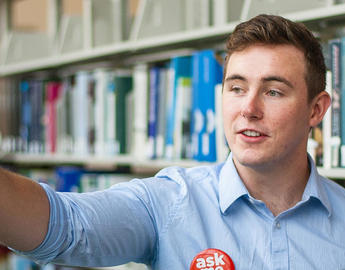 Student wearing an "Ask me" button