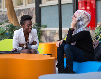 Two students chat in the atrium