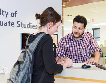 Students talk in front of the Faculty of Graduate Studies office