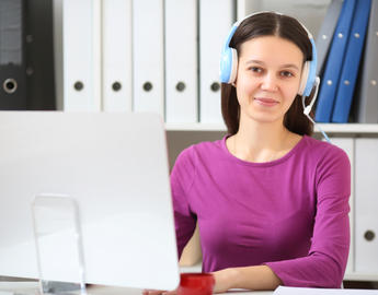 An online teacher smiles behind a computer