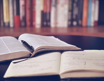 textbooks and notebook open on a table 