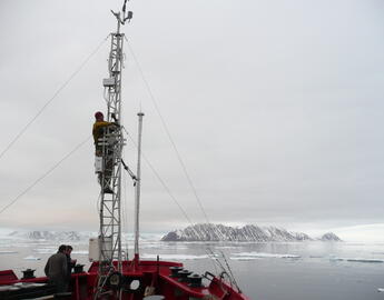 Man climbing machinery in the winter.